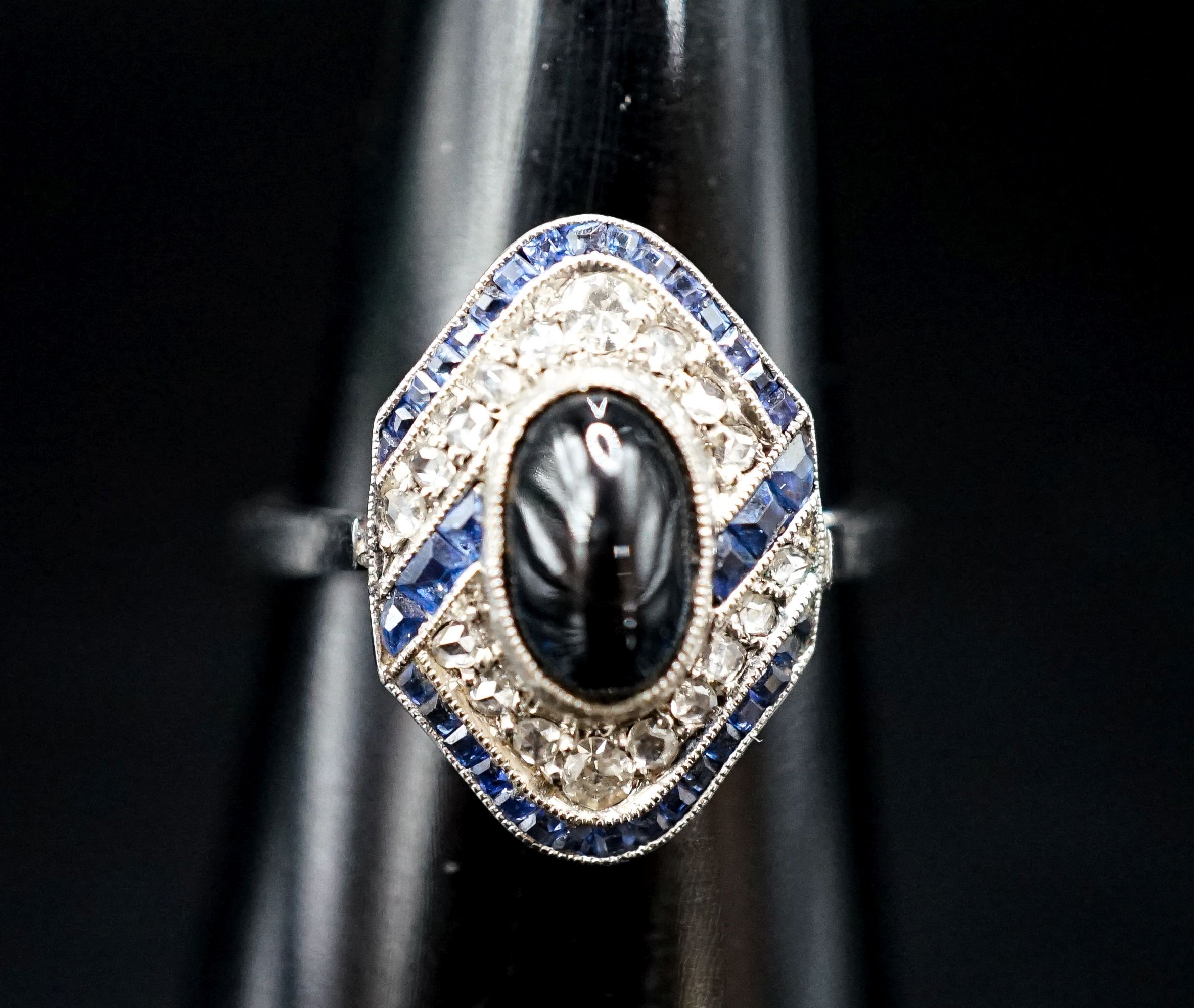 A 1920's white metal (stamped plat), sapphire and diamond ring, with central cabochon sapphire, size M, gross weight 4.6 grams.